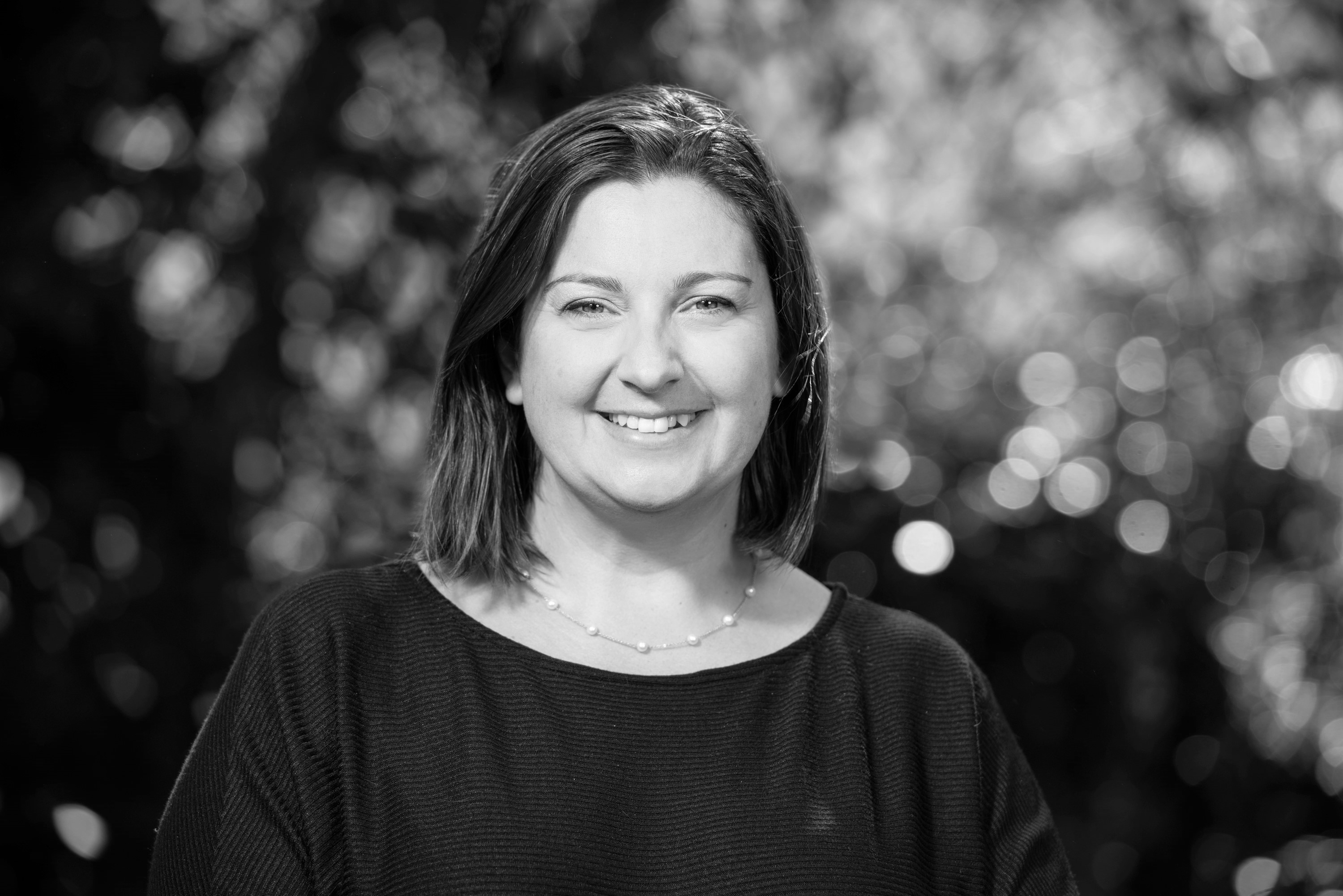 Black and white photo of Juliana Tadano in front of blurry background